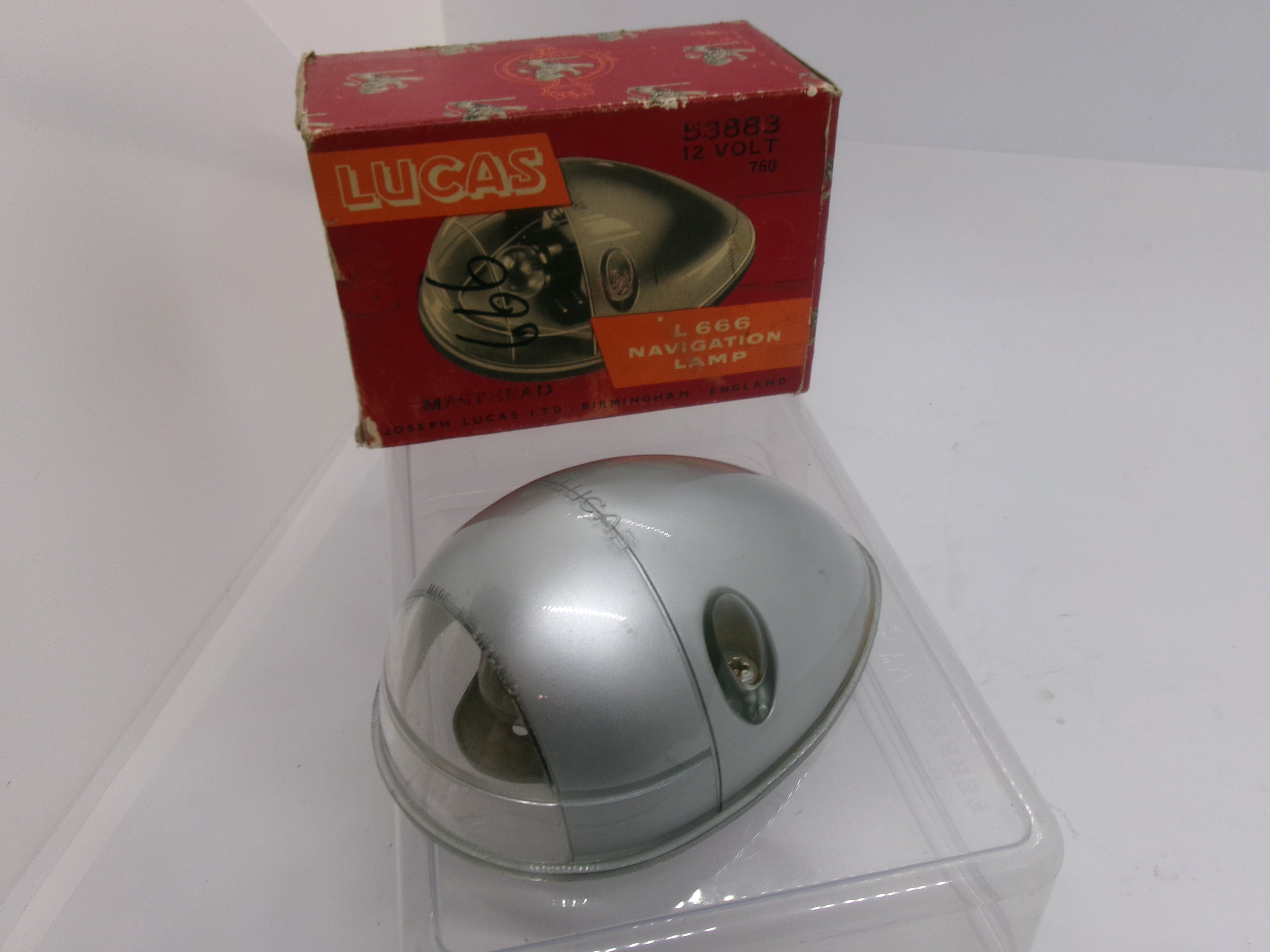 Silver dome-shaped object with a red 'Lucas' box on a white background
